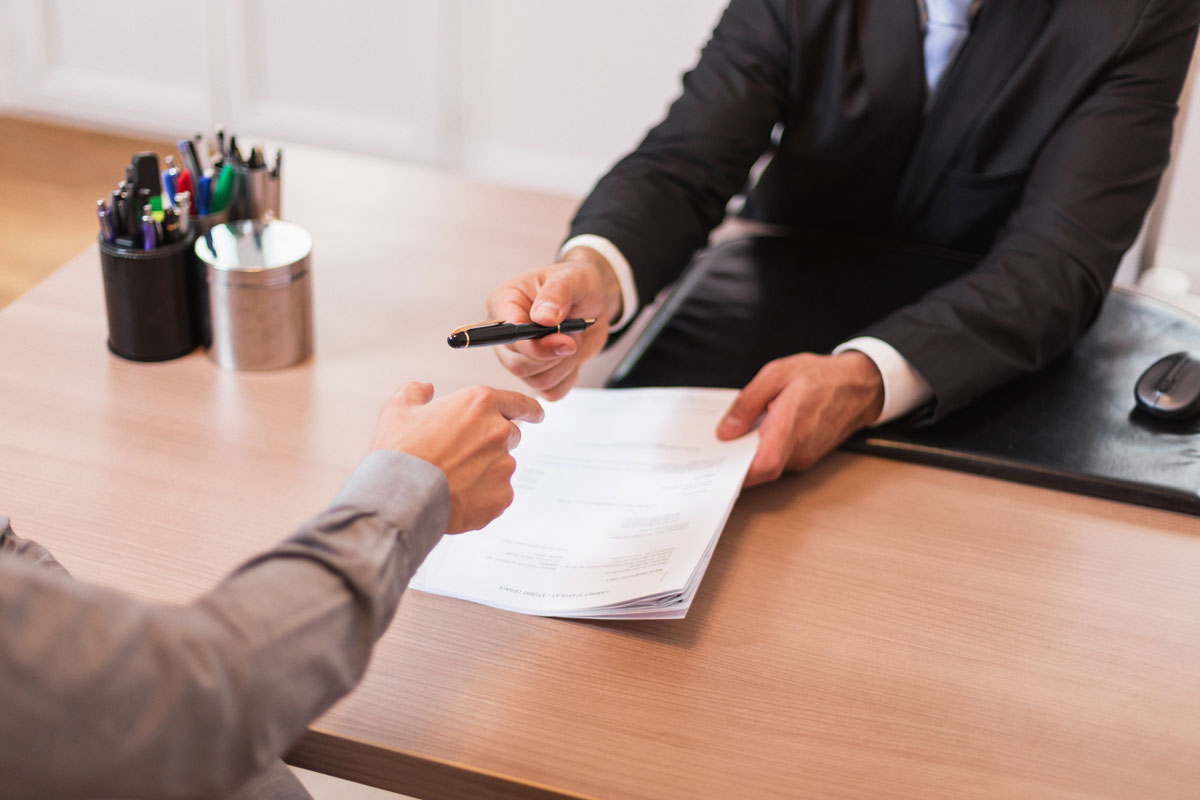 Un avocat contravention en réunion avec un client, signant des documents légaux.