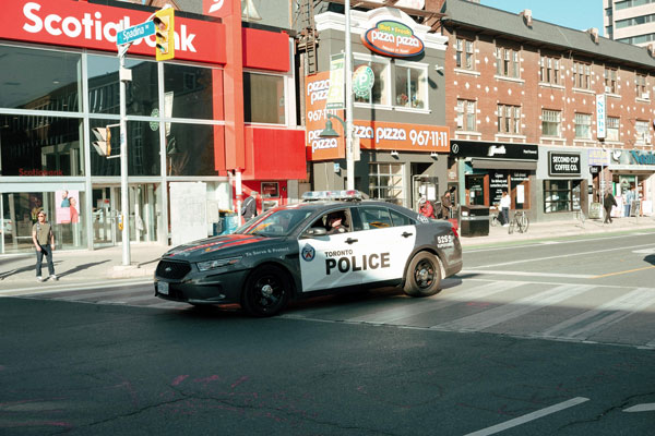 Une voiture de police patrouillant dans une rue passante.