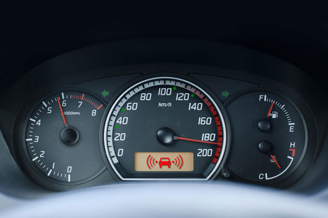 A car speedometer showing 185 km/h, indicating speeding.
