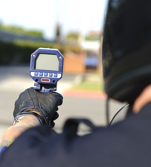Un policier utilisant un radar pour détecter des infractions d'excès de vitesse.