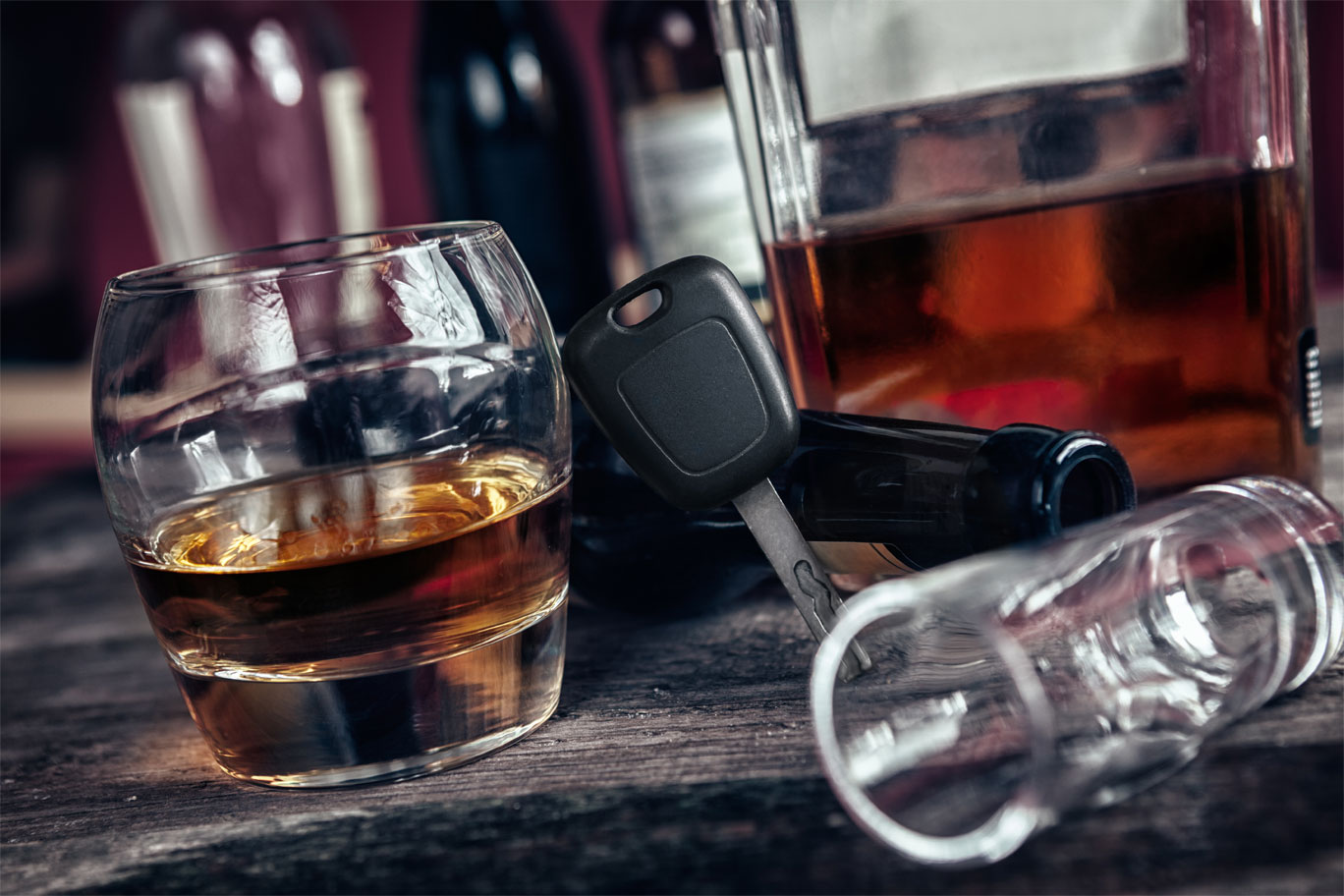 Un verre d'alcool et des clés de voiture sur une table, insinuant l'arrestation pour alcoolémie.