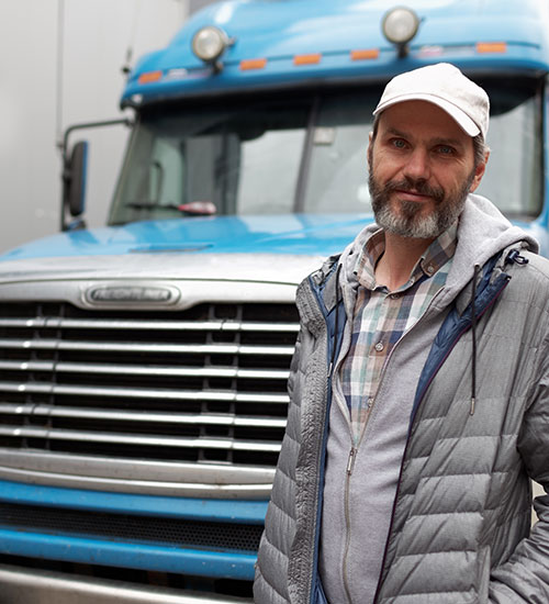 Travailleur près de son camion, soulignant l'importance d'un permis restreint pour le travail.