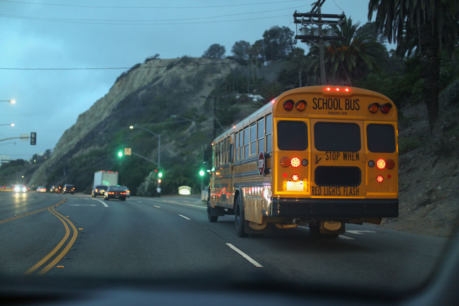 A school bus driving on a busy street.